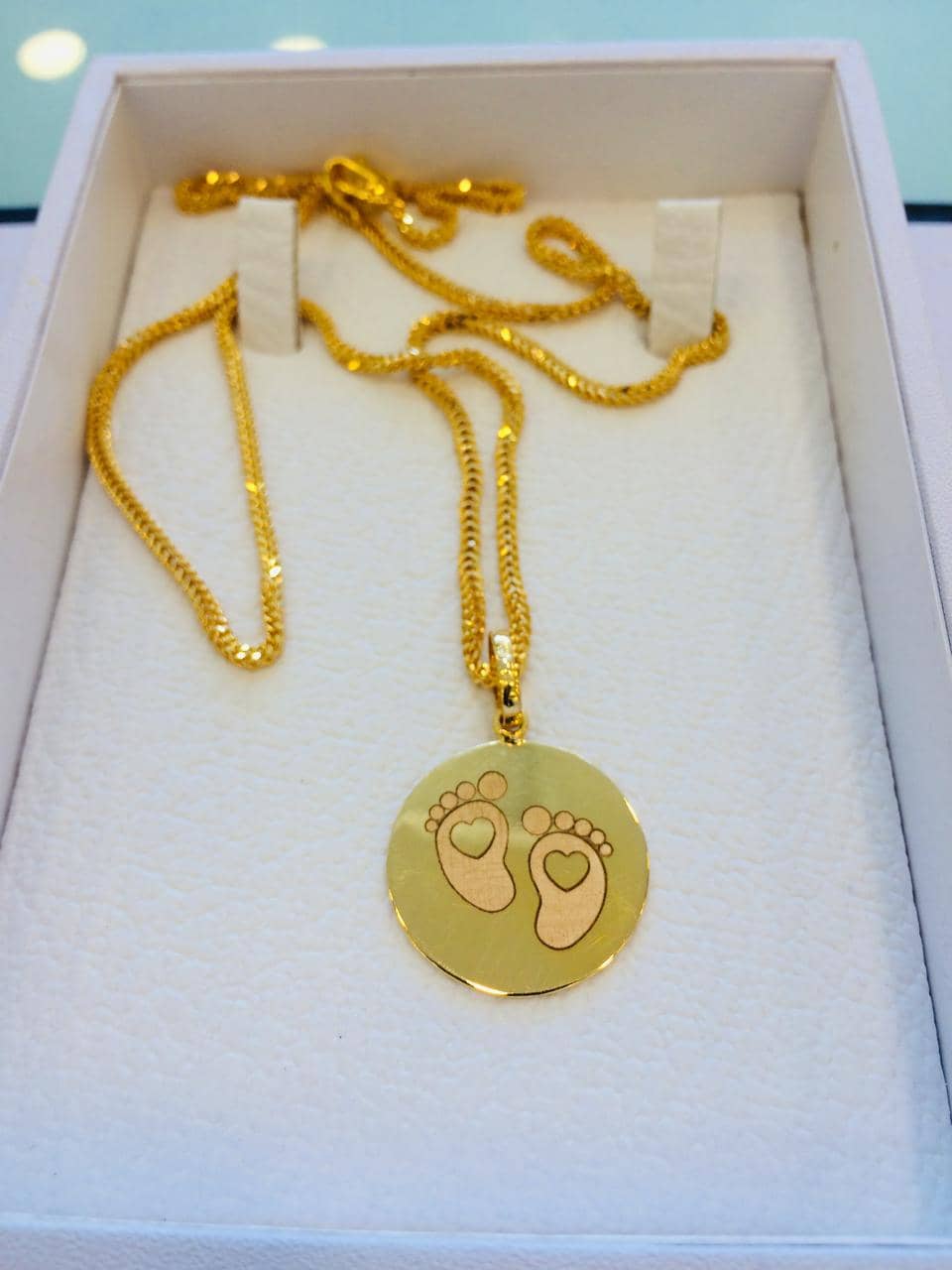 Gold pendant engraved with baby footprints