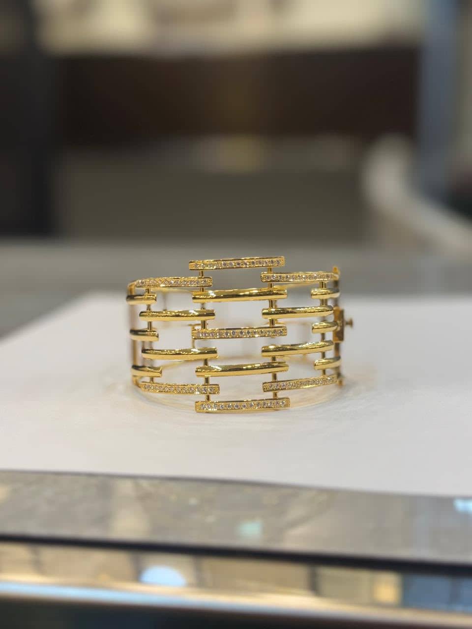 Wide gold cage-design ring with stone-set bars
