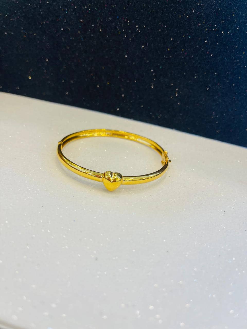 Slim gold bangle with a polished heart