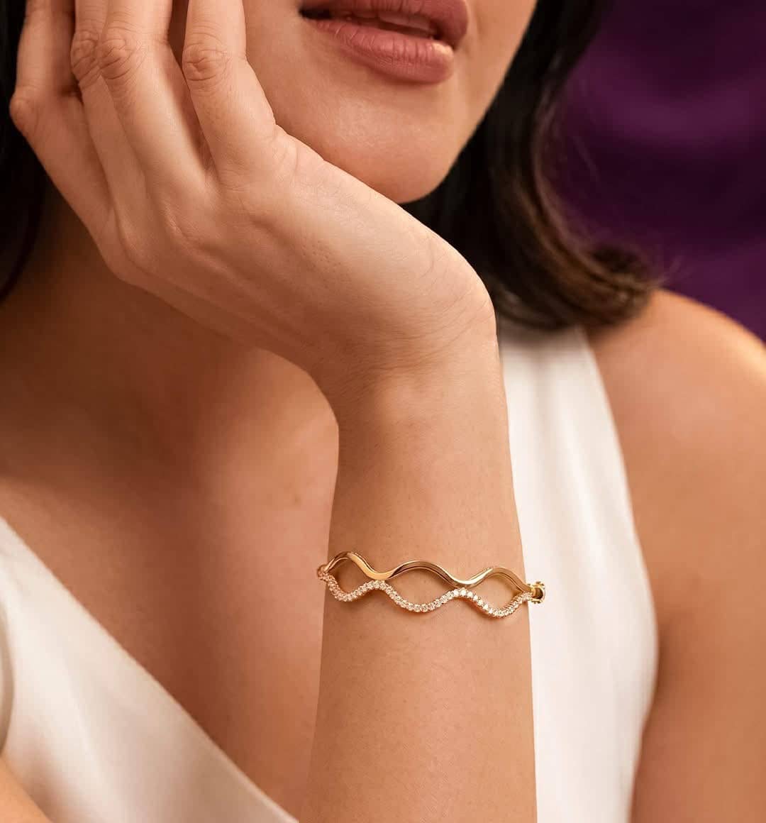 Wave-shaped gold bracelet with a line of sparkling stones