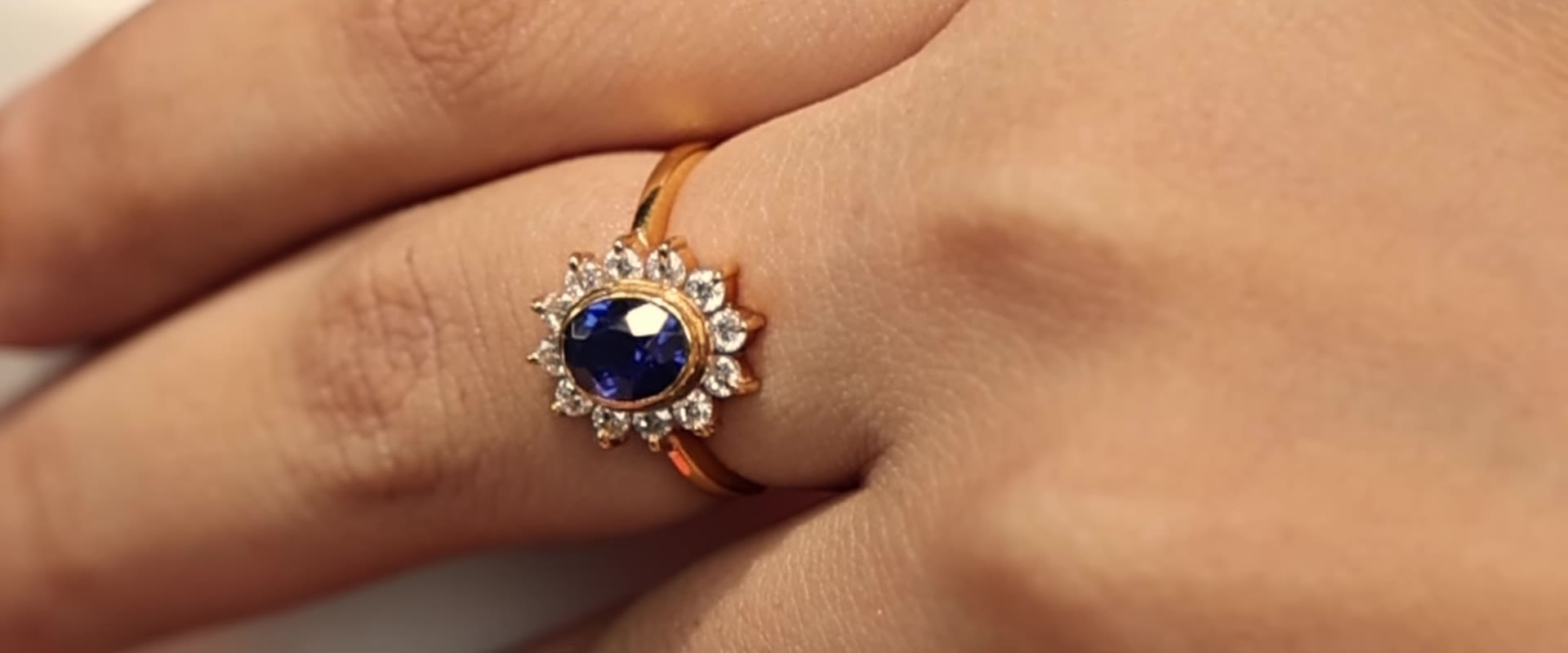 Gold ring with a blue sapphire surrounded by brilliant stones